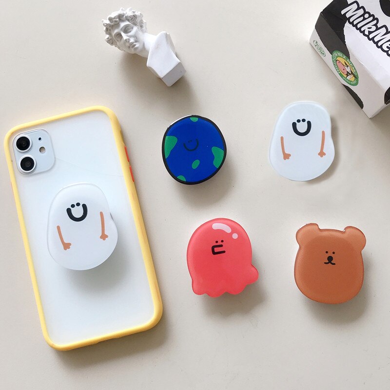 Cartoon Phone Socket. Attach these to your phone so you can hold it securely, prop it up whilst watching shows, or just fiddle around with it. Compatible with any phone!