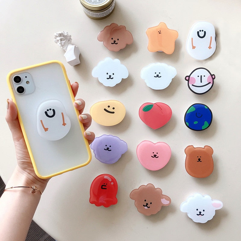 Cartoon Phone Socket. Attach these to your phone so you can hold it securely, prop it up whilst watching shows, or just fiddle around with it. Compatible with any phone!