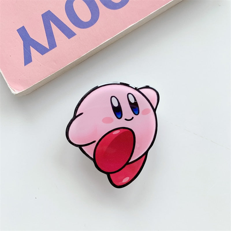 Kirby Cartoon Phone Socket. Griptok. Attach it to your phone so you can hold it securely, prop it up whilst watching shows, or just fiddle around with it. Compatible with any phone!