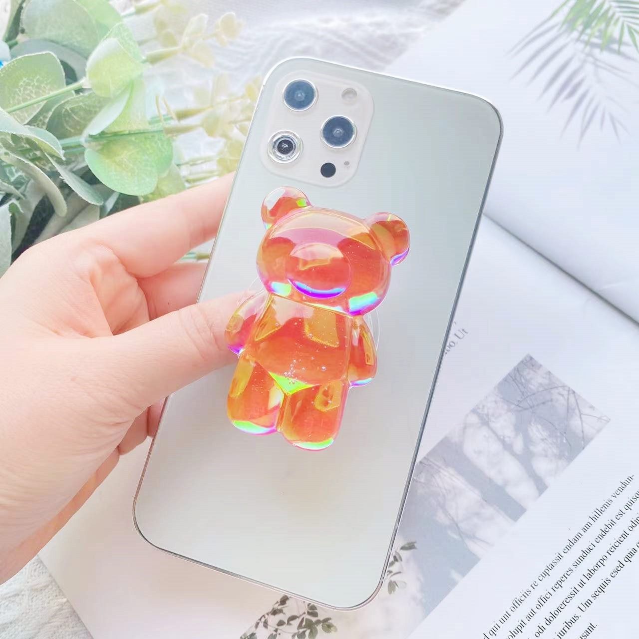 Orange Phone Pop Socket Bear. Attach it to your phone so you can hold it securely, prop it up whilst watching shows, or just fiddle around with it. Compatible with any phone!
