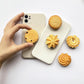 Phone Socket Danish Butter Cookies. Griptok. Attach it to your phone so you can hold it securely, prop it up whilst watching shows, or just fiddle around with it. Compatible with any phone!