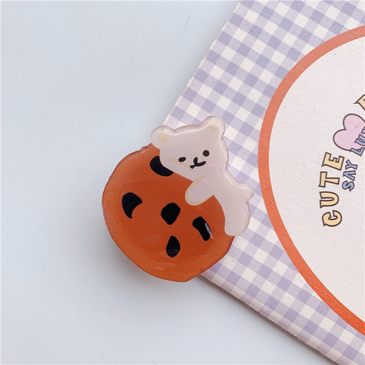 Cartoon Bear with Cookie Phone Socket. Attach these to your phone so you can hold it securely, prop it up whilst watching shows, or just fiddle around with it.  Compatible with any phone!