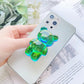 Green Pop Phone Socket Bear. Attach it to your phone so you can hold it securely, prop it up whilst watching shows, or just fiddle around with it. Compatible with any phone!