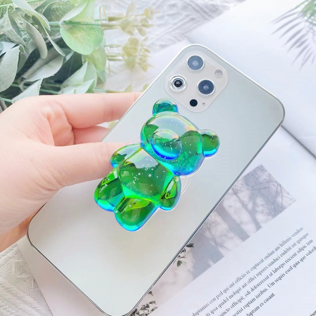 Green Pop Phone Socket Bear. Attach it to your phone so you can hold it securely, prop it up whilst watching shows, or just fiddle around with it. Compatible with any phone!