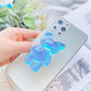 Blue Phone Pop Socket Bear. Attach it to your phone so you can hold it securely, prop it up whilst watching shows, or just fiddle around with it. Compatible with any phone!